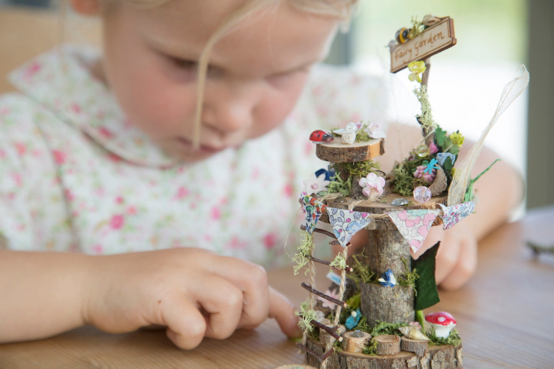 DIY fairy tree house with table, step ladder and tiny liberty print bunting