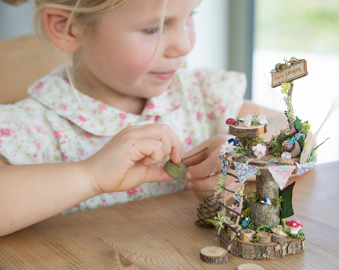 DIY fairy tree house with table, step ladder and tiny liberty print bunting